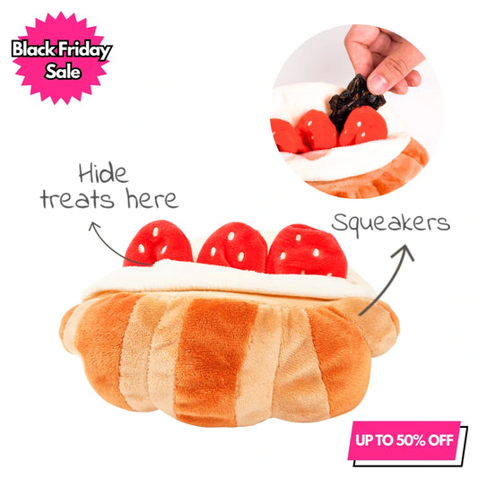 Strawberry croissant shaped plush squeaky dog toy featuring hidden treat pockets behind the strawberries for nosework play. The image includes "Black Friday Sale" and "Up to 50% OFF" promotional text, with an inset demonstrating how to hide treats inside the toy.